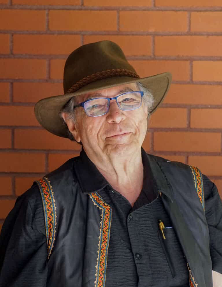 Antonio Nunez in front of brick wall near Allen Ginsberg Library