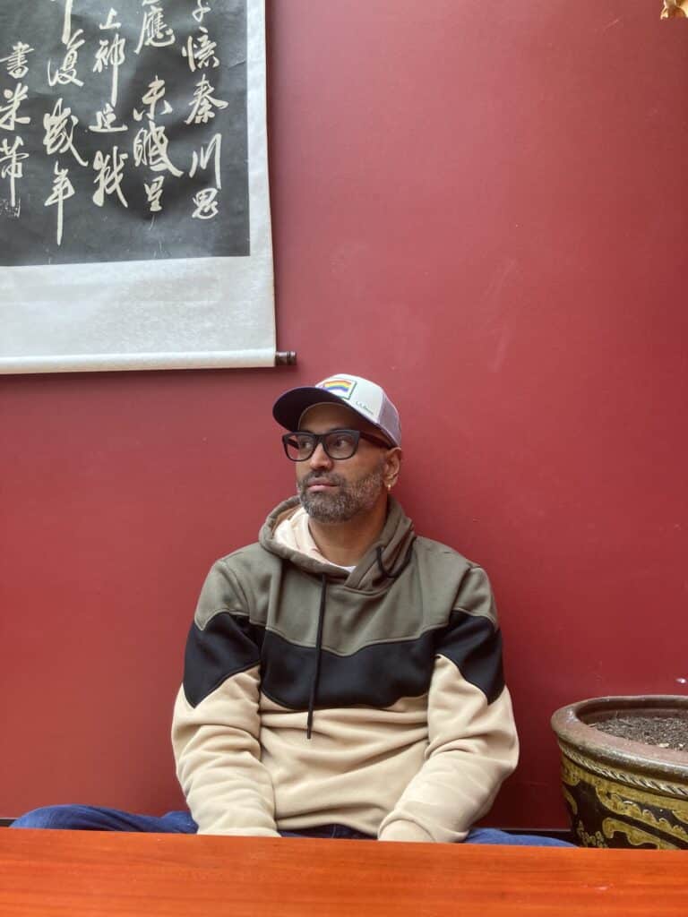 Rajiv Mohabir in sweatshirt at Ku Cha Tea House