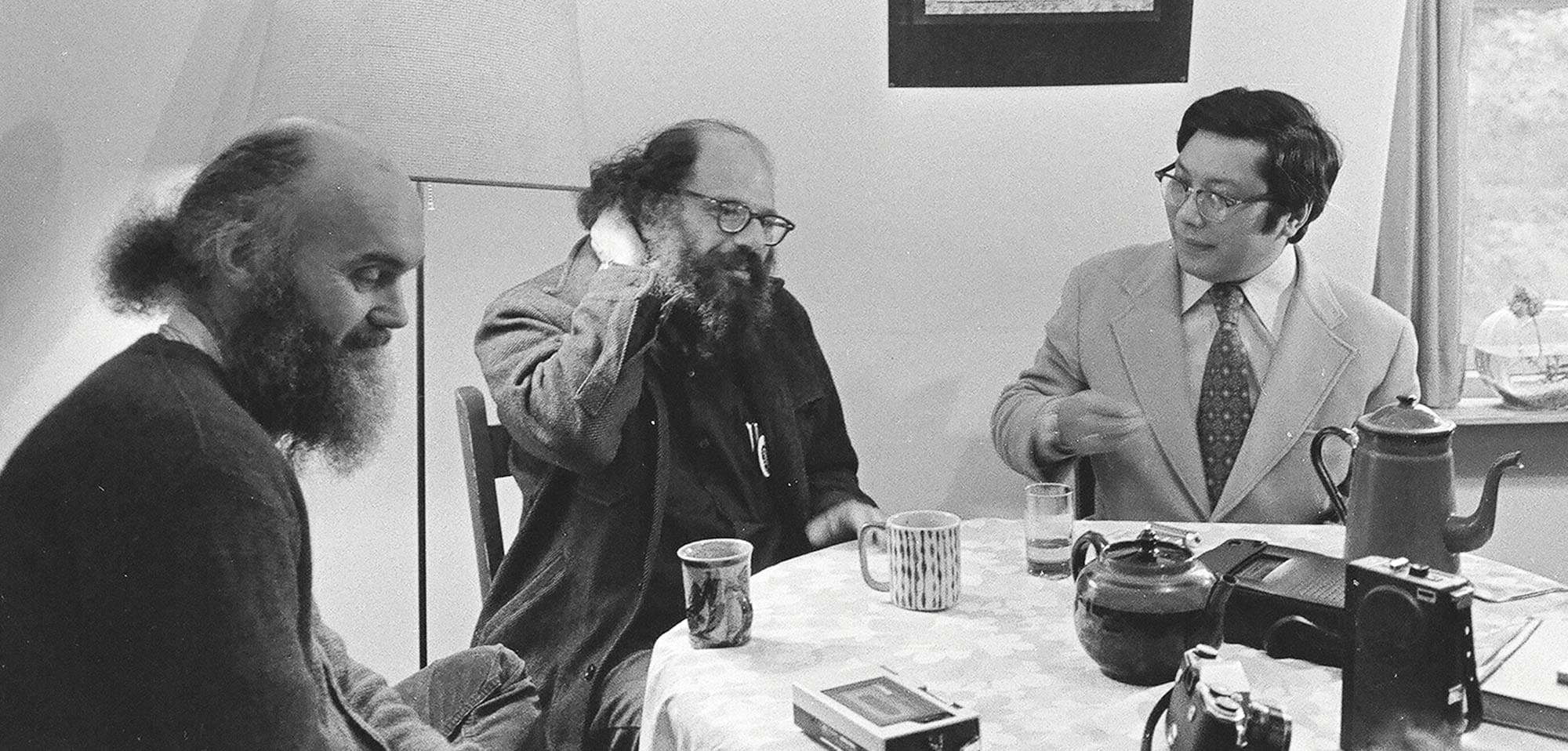 Ram Dass and Allen Ginsberg at a table in an apartment in Boulder